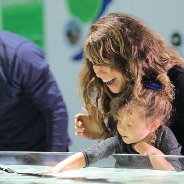 Mother and daughter touching fish at the Great Lakes Aquarium in Duluth Minnesota