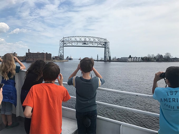 Children looking through binoculars at the Duluth Lift Bridge in Duluth, Minnesota, from a Vista Fleet boat